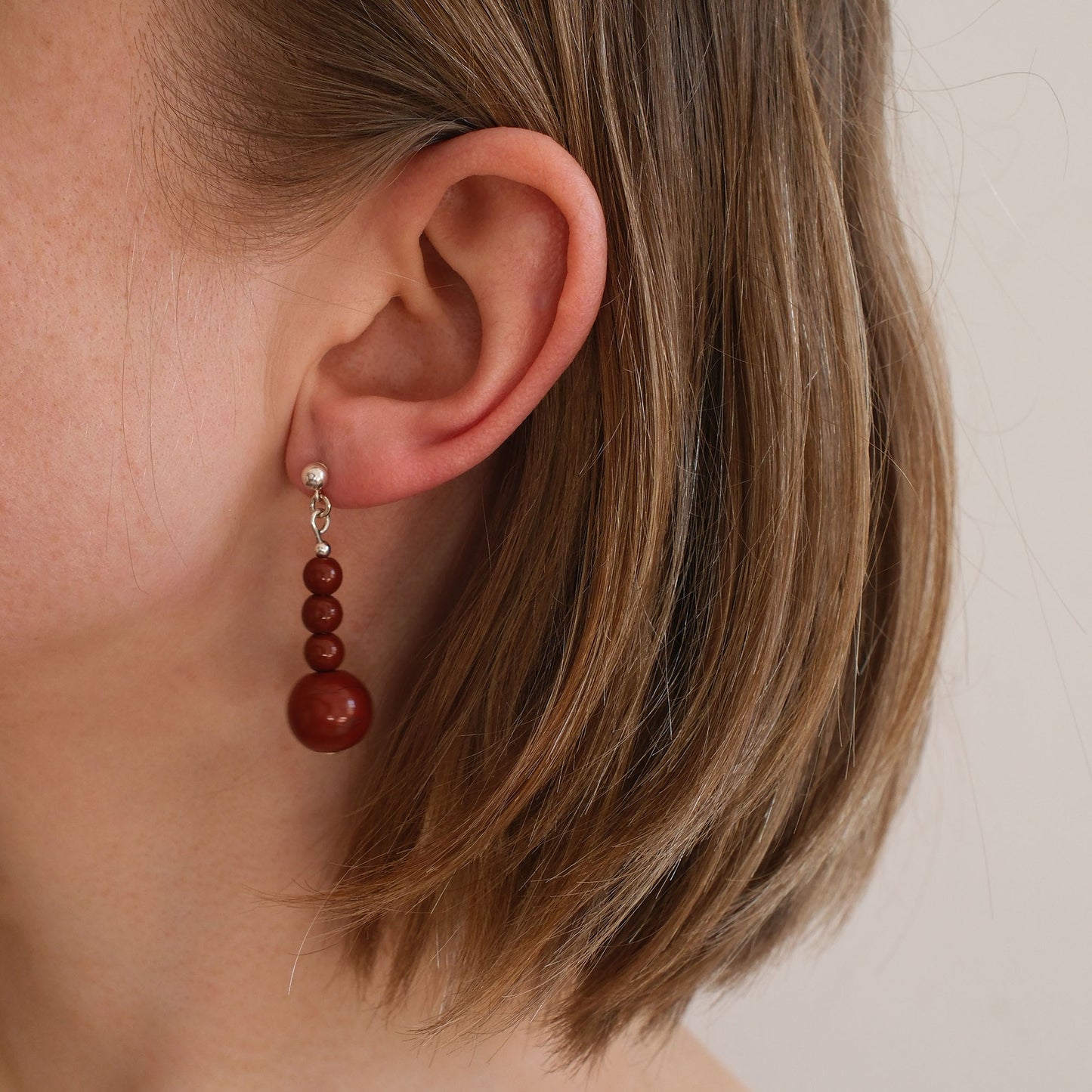 wiszące kolczyki z czerwonym kamieniem na modelce