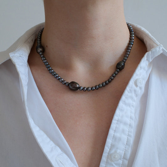 naszyjnik z szarą perłą na szyji