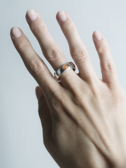 obrączka srebrna z kamieniem słonecznym na dłoni