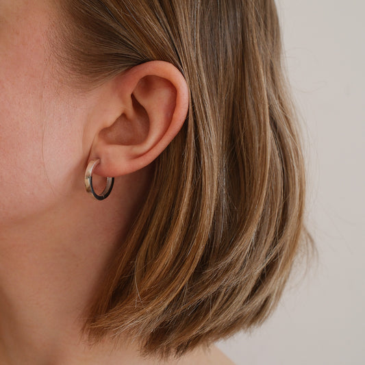 srebrne kolczyki na uchu