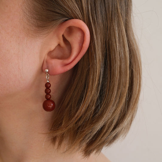 wiszące kolczyki z czerwonym kamieniem na modelce